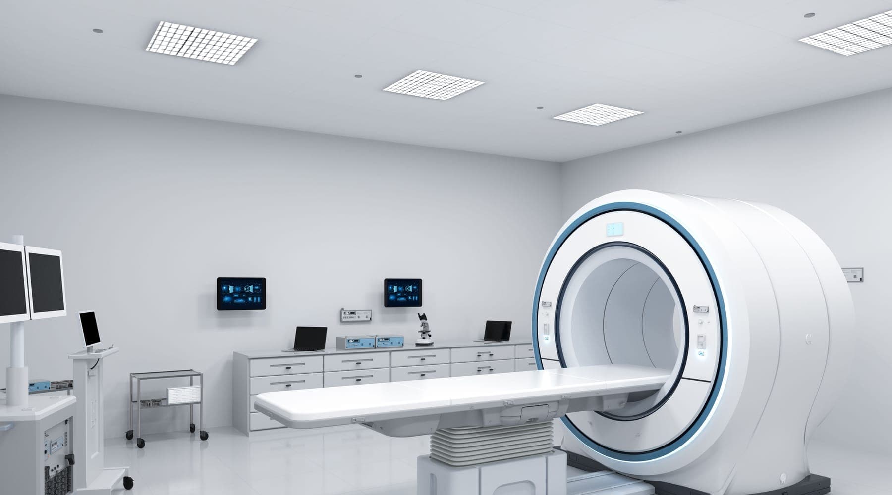 An MRI scanner and its patient table in a white imaging room, with workstations and cabinets along the wall